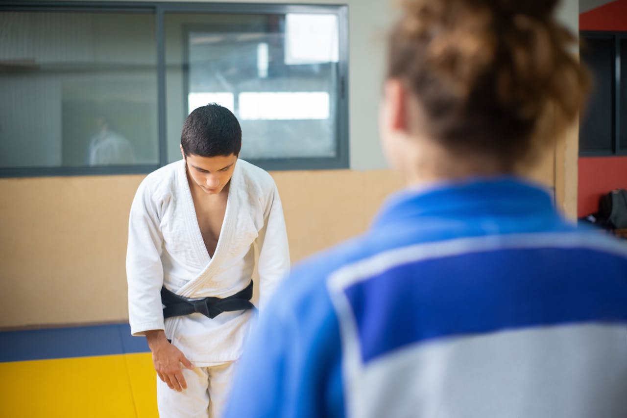 Man in judo uniform bowing to a person